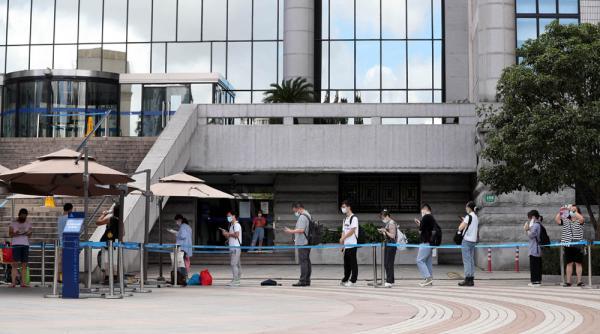 上海图书馆门前又见“芬兰式”排队,小姐姐举牌巡馆,提醒读者戴好口罩